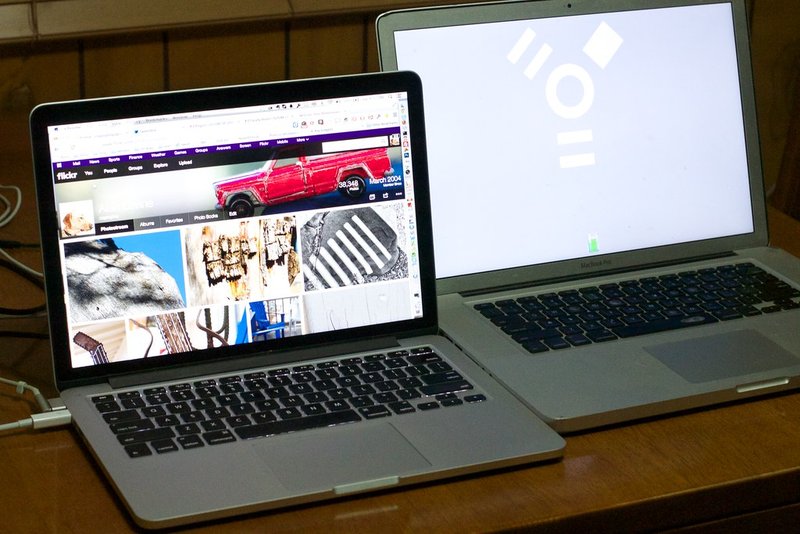 The dual laptops subtly relate to the theme of travel planning across devices—vaguely immersive.
